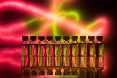 Eczane ve kimya teması. Araştırma laboratuarında çözeltisi olan cam deney şişesi. Bilim ve tıbbi geçmiş. Koyu renk arkaplan üzerinde laboratuvar test tüpleri, bilimsel araştırma ekipmanları konsepti