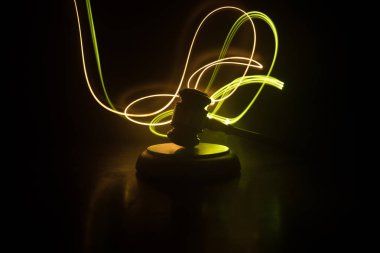 Hukuk tema, hakimin adalet heykeli ile ahşap masa üzerinde çekiç. Işık ile karanlık sisli zemin üzerine hukuk tokmak. Seçici odak