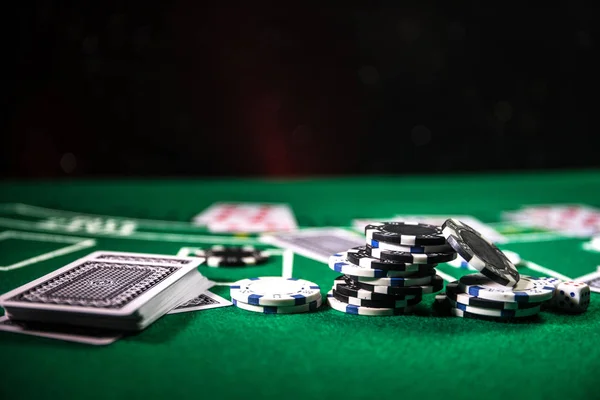 Cards and chips on green felt casino table. Abstract background with copy space. Gambling, poker, casino and cards games theme. Casino elements on green. Selective focus