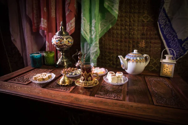 阿拉伯茶在玻璃与东方小吃在老式的木制表面 东方茶的概念 低浅色的休息室内饰 配有地毯 空的空间 选择性对焦 — 图库照片