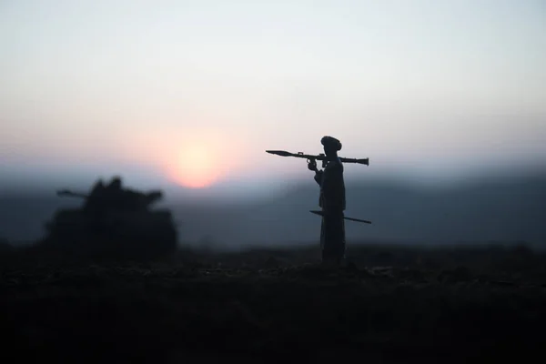 Military soldier silhouette with bazooka. War Concept. Military silhouettes fighting scene on war fog sky background, Soldier Silhouette aiming to the target at sunset. Attack scene