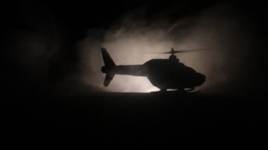 Askeri helikopter çatışma bölgesinden uçmaya hazır silüeti. Gece görüntüleri çöl sisli tonda sırt ile başlayarak helikopter ile dekore edilmiştir. Seçici odak.