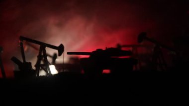 Sanat dekorasyonu. Petrol savaş konsepti. Petrol sahasında pompa ve kuleleri olan askeri siluetler. Misty renkli gökyüzü arka plan. Zırhlı araçlar dövüş sahnesi. 