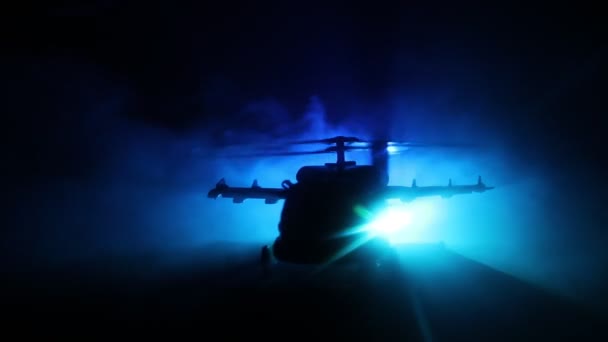 Silueta de helicóptero militar lista para volar desde zona de conflicto. Imágenes nocturnas decoradas con helicóptero comenzando en el desierto con niebla tonificada retroiluminada. Enfoque selectivo . — Vídeos de Stock