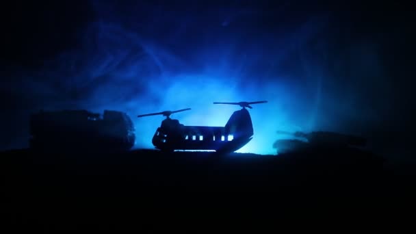 Silhueta de helicóptero militar pronta para voar da zona de conflito. Filmagem noturna decorada com helicóptero começando no deserto com nevoeiro tonificado retroiluminado. Foco seletivo . — Vídeo de Stock