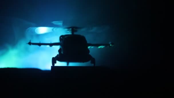 Silueta vojenský vrtulník připravený k letu z oblastí ozbrojených konfliktů. Noční záběry zdobené vrtulník v poušti s mlhavé tónovaný podsvícení. Selektivní fokus. — Stock video