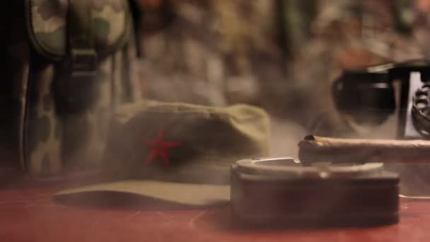 キューバ産の葉巻と木製のテーブルの上の灰皿をクローズ アップ 暗い部屋で共産主義独裁者の司令官のテーブル 軍隊大将の仕事の表の概念です アートワークの装飾 — ストック動画