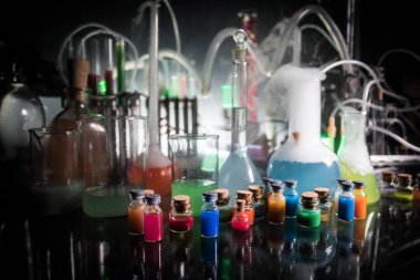 Eczane ve kimya teması. Araştırma laboratuarında çözeltisi olan cam deney şişesi. Bilim ve tıbbi geçmiş. Koyu renk arkaplan üzerinde laboratuvar test tüpleri, bilimsel araştırma ekipmanları konsepti