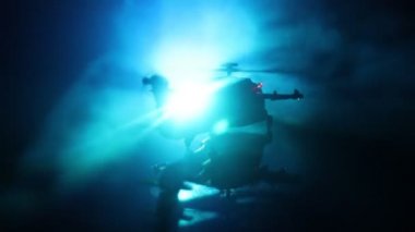 Askeri helikopter çatışma bölgesinden uçmaya hazır silüeti. Gece görüntüleri çöl sisli tonda sırt ile başlayarak helikopter ile dekore edilmiştir. Seçici odak.
