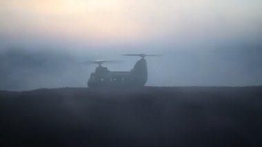 Askeri helikopter çatışma bölgesinden uçmaya hazır silüeti. Gece görüntüleri çöl sisli tonda sırt ile başlayarak helikopter ile dekore edilmiştir. Seçici odak.