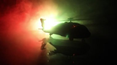 Askeri helikopter çatışma bölgesinden uçmaya hazır silüeti. Gece görüntüleri çöl sisli tonda sırt ile başlayarak helikopter ile dekore edilmiştir. Seçici odak.