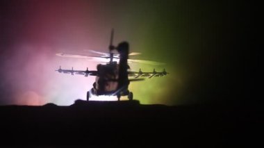 Askeri helikopter çatışma bölgesinden uçmaya hazır silüeti. Gece görüntüleri çöl sisli tonda sırt ile başlayarak helikopter ile dekore edilmiştir. Seçici odak.