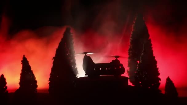 Silueta de helicóptero militar lista para volar desde zona de conflicto. Imágenes nocturnas decoradas con helicóptero comenzando en el desierto con niebla tonificada retroiluminada. Enfoque selectivo . — Vídeo de stock