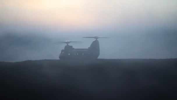 Silhouette d'hélicoptère militaire prêt à décoller de la zone de conflit. Images de nuit décorées avec hélicoptère commençant dans le désert avec rétroéclairage tonique brumeux. Concentration sélective . — Video