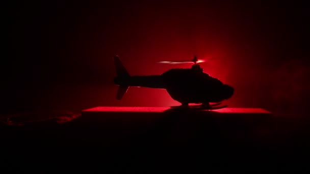 Silhouette eines Militärhubschraubers, der bereit ist, aus dem Konfliktgebiet zu fliegen. dekorierte Nachtaufnahmen mit Helikoptern, die in der Wüste mit nebelgetöntem Gegenlicht starten. Selektiver Fokus. — Stockvideo