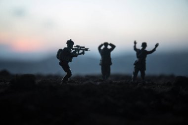 Savaş sahnesi. Askeri savaş sis gökyüzü arka plan üzerinde mücadele sahne siluetleri. Bir Alman askeri silah teslim ortaya çıkar. Plastik oyuncak askerler silahlı düşman askeri esir alarak. Sanat