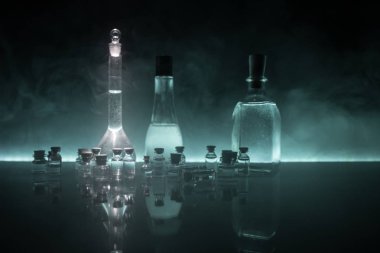 Eczane ve kimya teması. Araştırma laboratuarında çözeltisi olan cam deney şişesi. Bilim ve tıbbi geçmiş. Koyu renk arkaplan üzerinde laboratuvar test tüpleri, bilimsel araştırma ekipmanları konsepti