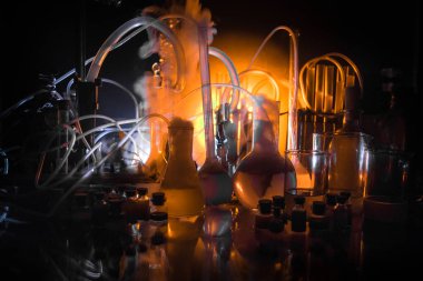 Eczane ve kimya teması. Araştırma laboratuarında çözeltisi olan cam deney şişesi. Bilim ve tıbbi geçmiş. Koyu renk arkaplan üzerinde laboratuvar test tüpleri, bilimsel araştırma ekipmanları konsepti