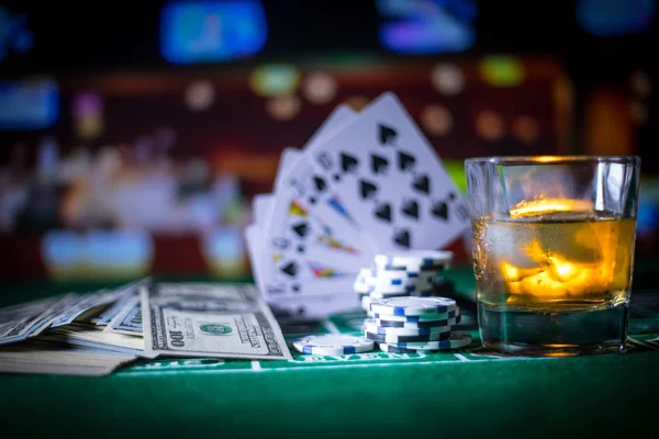 gambling, fortune, game and entertainment concept - close up of casino chips and whisky glass on table. Selective focus