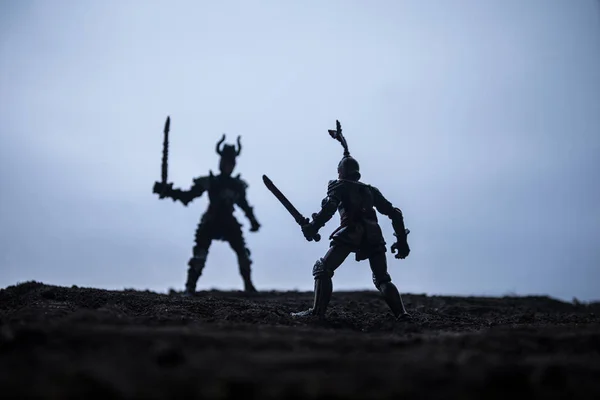 stock image Medieval battle scene with cavalry and infantry. Silhouettes of figures as separate objects, fight between warriors on sunset foggy background. Selective focus