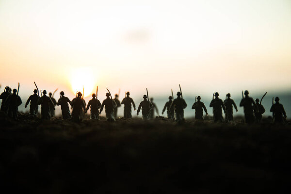 Концепция войны. Военные силуэты боевой сцены на фоне тумана войны, силуэты солдат мировой войны под облачным горизонтом на закате. Сцена нападения. Бронетехника. танк в действии
