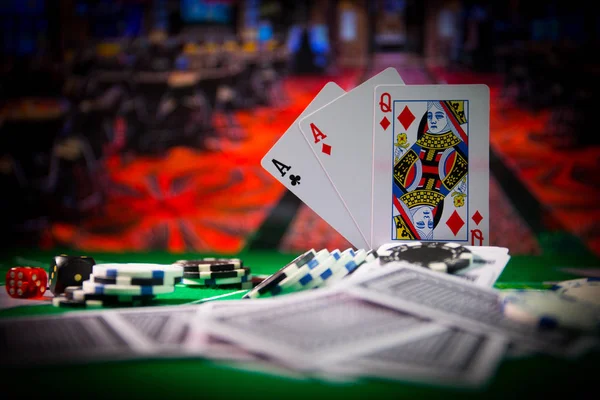 Cards and chips on green felt casino table. Abstract background with copy space. Gambling, poker, casino and cards games theme. Casino elements on green. Selective focus