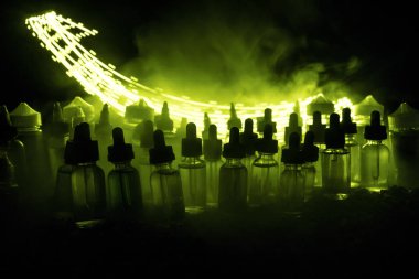 Vape kavramı. Duman bulutları ve vape sıvı şişe koyu arka plan üzerinde. Işık efektleri. Arka plan veya elektronik sigara reklam olarak kullanışlıdır. Seçici odak