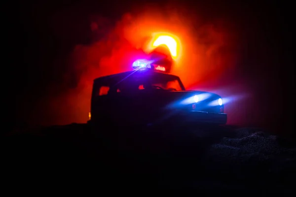 Police cars at night. Police car chasing a car at night with fog background. 911 Emergency response police car speeding to scene of crime. Selective focus