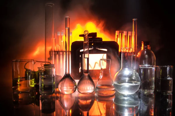 Eczane ve kimya teması. Araştırma laboratuarında çözeltisi olan cam deney şişesi. Bilim ve tıbbi geçmiş. Koyu renk arkaplan üzerinde laboratuvar test tüpleri, bilimsel araştırma ekipmanları konsepti