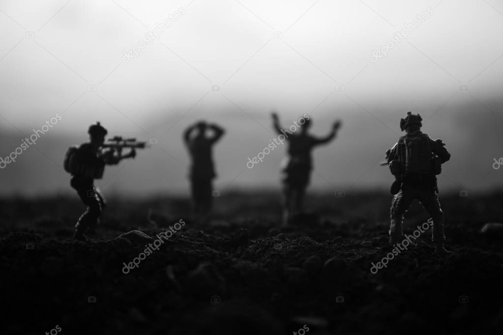 Battle scene. Military silhouettes fighting scene on war fog sky background. A German soldiers raised arms to surrender. Plastic toy soldiers with guns taking prisoner the enemy soldier. Artwork