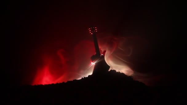 音楽のコンセプト 煙と光のビームの下で暗い背景で アコースティック ギター 本文空スペース 効果を発生します シュールなギター — ストック動画