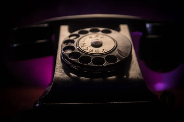 old black telephone on old wood plank with art dark background with fog and toned light. empty space. Selective focus