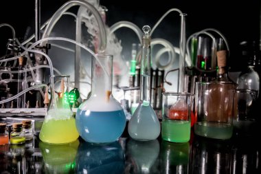 Eczane ve kimya teması. Araştırma laboratuarında çözeltisi olan cam deney şişesi. Bilim ve tıbbi geçmiş. Koyu renk arkaplan üzerinde laboratuvar test tüpleri, bilimsel araştırma ekipmanları konsepti