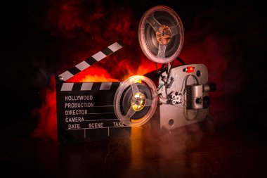 Old vintage movie projector on a dark background with fog and light. Concept of film-making. Selective focus clipart