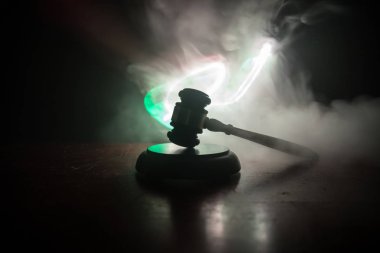 Hukuk tema, hakimin adalet heykeli ile ahşap masa üzerinde çekiç. Işık ile karanlık sisli zemin üzerine hukuk tokmak. Seçici odak