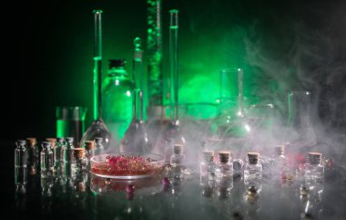 Eczane ve kimya teması. Araştırma laboratuarında çözeltisi olan cam deney şişesi. Bilim ve tıbbi geçmiş. Koyu renk arkaplan üzerinde laboratuvar test tüpleri, bilimsel araştırma ekipmanları konsepti