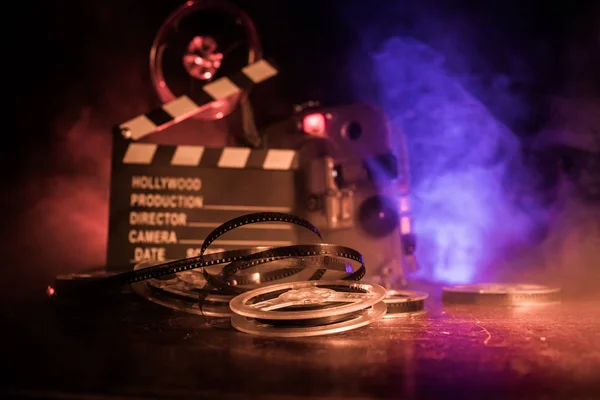 Old vintage movie projector on a dark background with fog and light. Concept of film-making. Selective focus