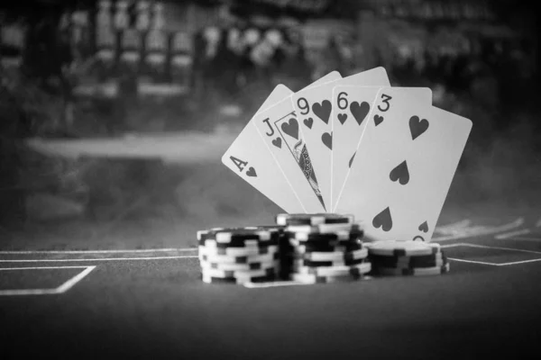 Cards and chips on green felt casino table. Abstract background with copy space. Gambling, poker, casino and cards games theme. Casino elements on green. Selective focus