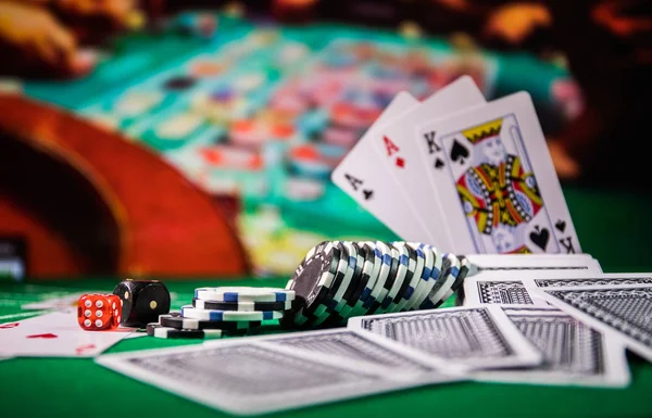 Cards and chips on green felt casino table. Abstract background with copy space. Gambling, poker, casino and cards games theme. Casino elements on green. Selective focus