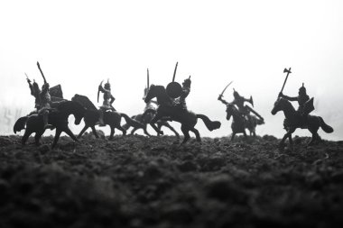 Süvari ve piyade ile ortaçağ savaş sahnesi. Siluetleri şekiller ayrı nesneler olarak mücadele günbatımı sisli arka plan savaşçılar arasında. Seçici odak