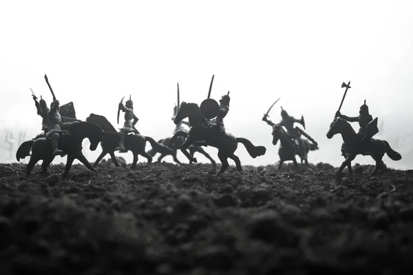 Escena de batalla medieval con caballería e infantería. Siluetas de figuras como objetos separados, lucha entre guerreros sobre fondo brumoso puesta de sol. Enfoque selectivo —  Fotos de Stock