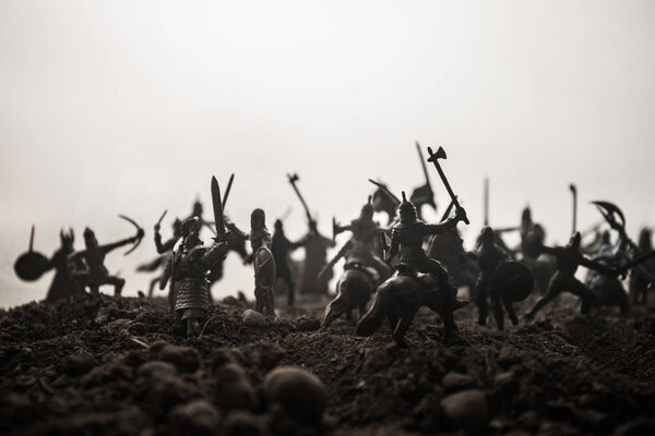Средневековая боевая сцена с кавалерией и пехотой. Силуэты фигур как отдельные объекты, борьба между воинами на закатном туманном фоне. Селективный фокус
