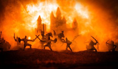 Süvari ve piyade ile ortaçağ savaş sahnesi. Siluetleri şekiller ayrı nesneler olarak mücadele günbatımı sisli arka plan savaşçılar arasında. Seçici odak