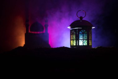 Gece karanlık tonda sisli arka plan üzerinde parlayan mum yanan ile süs Arapça fener. Bayram tebrik kartı, Müslüman kutsal ay ramazan Kareem(Eid Holiday) koyu arka plan için davet.