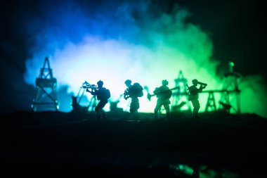 Resim dekorasyon. Petrol savaş kavramı. Askeri siluetleri, pompalar ve kulelerimiz petrol sahası. Puslu renkli gökyüzü arka plan. Zırhlı araçlar mücadele sahne. Seçici odak