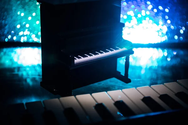 Concetto creativo. Decorazione d'arte con pianoforte su sfondo scuro nebbioso tonica con luce . — Foto Stock