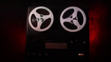 Koyu tonda sisli arka plan üzerinde makara oynatıcı ve kaydedici eski vintage makara. Analog Stereo Açık Makara Bant Güverte Kaydedici Çalar Makaralar ile. Seçici odaklama