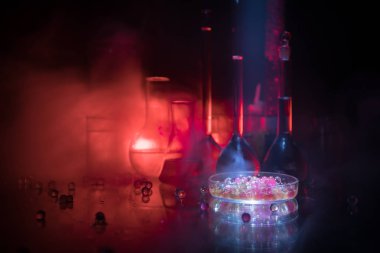 Eczane ve kimya teması. Araştırma laboratuarında çözeltisi olan cam deney şişesi. Bilim ve tıbbi geçmiş. Koyu renk arkaplan üzerinde laboratuvar test tüpleri, bilimsel araştırma ekipmanları konsepti