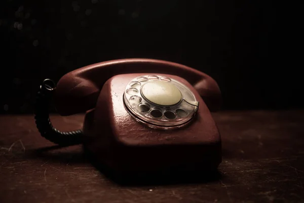 old black telephone on old wood plank with art dark background with fog and toned light. empty space. Selective focus