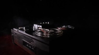Koyu tonda sisli arka plan üzerinde makara oynatıcı ve kaydedici eski vintage makara. Analog Stereo Açık Makara Bant Güverte Kaydedici Çalar Makaralar ile. Seçici odaklama